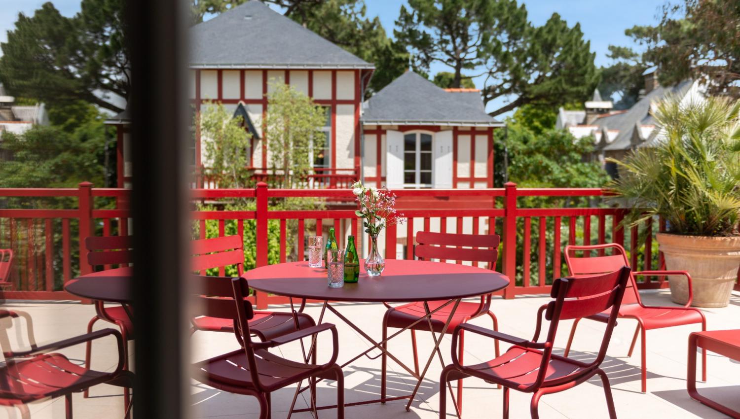 terrasse rouge et blanche et vue sur le jardin - hotel saint christophe
